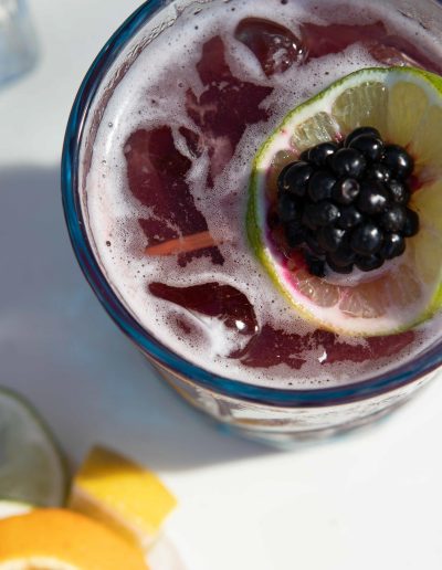 Top view close up of a tropical drink and the bottle of Yacht Life Vodka.