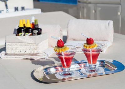 Two drinks served on a silver tray, on the top deck of a yacht