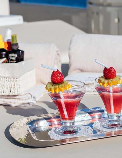 Two drinks served on a silver tray, on the top deck of a yacht